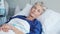 Senior woman resting and smiling on hospital bed