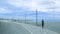 Senior woman running in a promenade against a blue cloudy sky. Active ageing concept and empty copy space