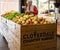 Senior woman selecting fresh apples at market and putting them into basket. An elderly woman choosing apples