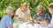 Senior woman serving breakfast in garden