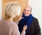 Senior woman setting scarf on man