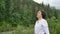 Senior woman with short dark hair doing a stretching exercise for relaxation in the morning outside over landscape of