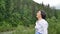 Senior woman with short dark hair doing a stretching exercise for relaxation in the morning outside over landscape of