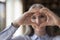 Senior woman showing finger heart shaped hands in focus