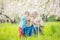 Senior woman showing something in hand to great grandson while relaxing in orchard