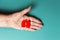 A senior woman shows in her palm, a silhouette of sick red lungs cut out of felt. Close up. Flay lay. Lung cancer