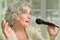 Senior woman singing with microphone