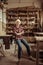 Senior woman sitting on chair against shelves with pottery goods