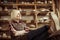 Senior woman sitting on chair with legs on table against shelves with pottery goods