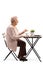 Senior woman sitting at a table with coffee and gesturing with hand