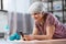 senior woman with smartphone exercising at home