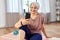 senior woman with smartphone exercising at home