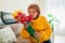 Senior woman smelling bouquet of tulips from her kids at home. Mother`s day present