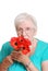 Senior woman smelling fake red poppies