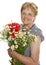 Senior woman smiling with bunch of wild flowers