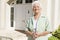 Senior woman standing outside house