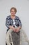 Senior Woman staying and smiling near Chair