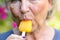 Senior woman sucking on an iced orange lolly