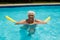 Senior woman swimming with inflatable tube