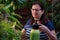 Senior woman taking care of houseplants, spraying a plant with water from a spray bottle