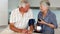 Senior woman taking her husbands blood pressure