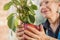 Senior woman tending home plant