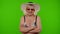 Senior woman tourist in swimsuit bra and red sunglasses, looking at camera, smiling on chroma key