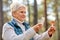 Senior woman using smartphone to identify mushroom