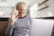 Senior woman video calling on a laptop, waving at screen