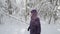 Senior woman walking past camera in winter forest