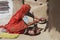 Senior woman wearing traditional dress does housework in a backyard of a house in Jamba, India.