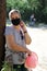 Senior woman wears a protective mask for a walk during the coronavirus. Elderly woman in a surgical mask on a walk in the park.