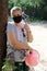Senior woman wears a protective mask for a walk during the coronavirus. Elderly woman in a surgical mask on a walk in the park.