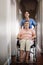 Senior woman, wheelchair and nurse with homecare helping, healthcare service and disability support. Caregiver, disabled