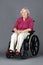 Senior woman in wheelchair over grey