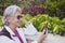 Senior woman with white hair and eyeglasses using cellphone, smiles and happiness for a retired people enjoying freedom and