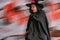 Senior woman in witch costumes celebrating Halloween posing on broom with motion blur items