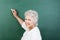 Senior woman writing on a chalkboard