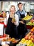 Senior woman and young man offering seasonal fruits