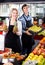 Senior woman and young man offering seasonal fruits