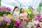 Senior women with daugther choosing orchids in a large store.