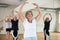 Senior women in sportswear dancing ballet inside gym