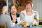 Senior women talking with girl while tea drinking