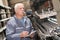 senior worker counting metal bars in warehouse