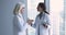 Senior and young women physicians shake hands in clinic office