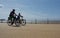 Seniors cycling on the promenade at seaside resort.