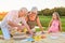 Seniors with grandchild having picnic.