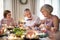 Seniors sitting at the table on a indoor family birthday party, eating.