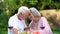 Seniors sitting at table and remembering their life together, happy marriage