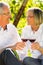 Seniors sitting in vineyard drinking red wine